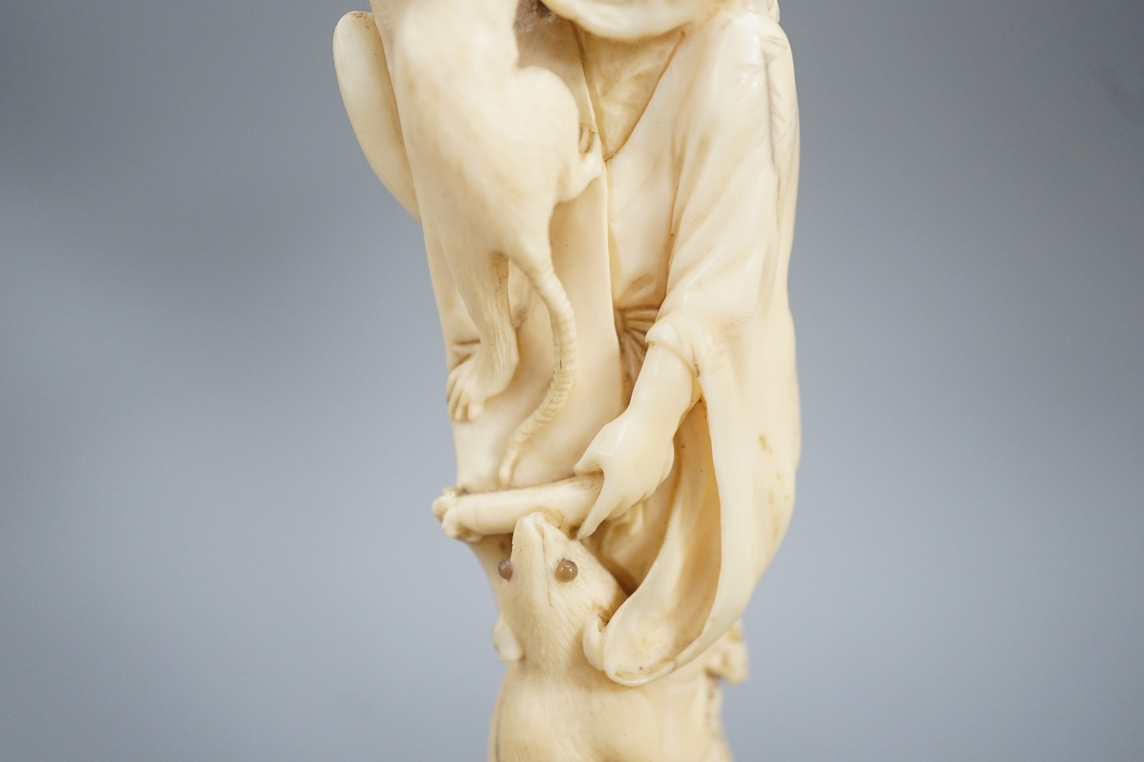 A Japanese ivory okimono of a man with giant rats clambering over him, signed, late 19th century 12.5cm, wood stand